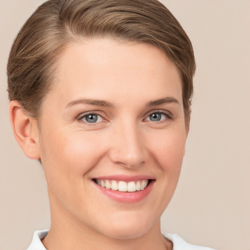 Joyful white young-adult female with short  brown hair and grey eyes