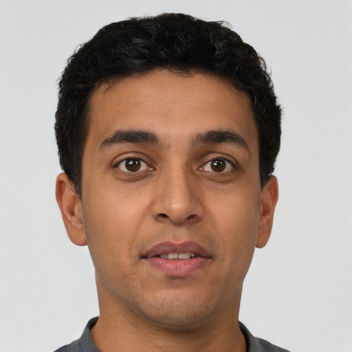 Joyful latino young-adult male with short  brown hair and brown eyes