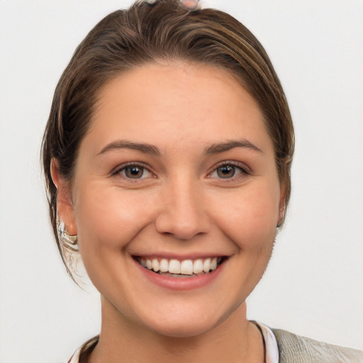 Joyful white young-adult female with medium  brown hair and grey eyes