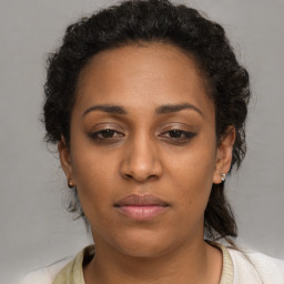 Joyful black adult female with medium  brown hair and brown eyes