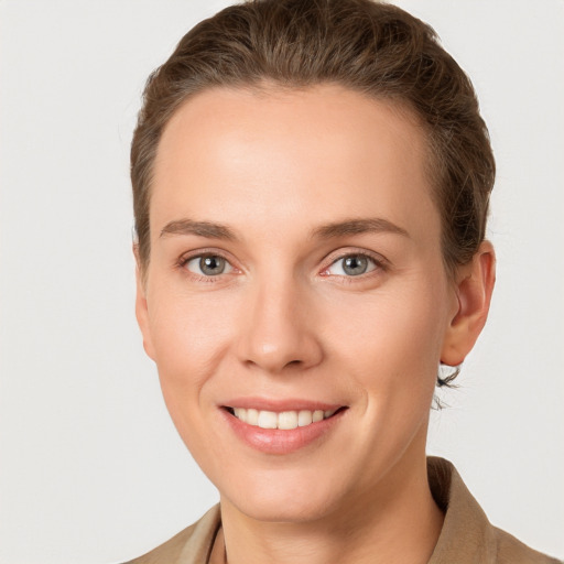 Joyful white young-adult female with short  brown hair and grey eyes