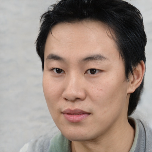 Joyful asian young-adult male with medium  brown hair and brown eyes