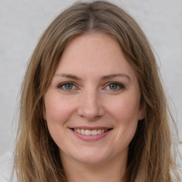 Joyful white young-adult female with long  brown hair and grey eyes