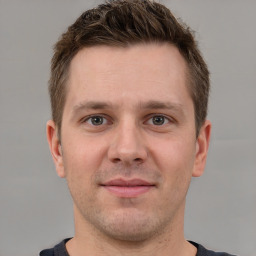 Joyful white young-adult male with short  brown hair and grey eyes