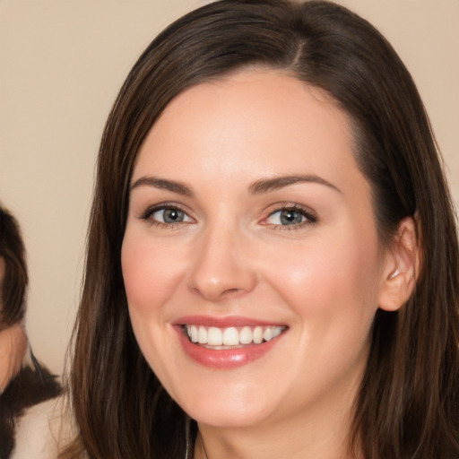 Joyful white young-adult female with long  brown hair and brown eyes