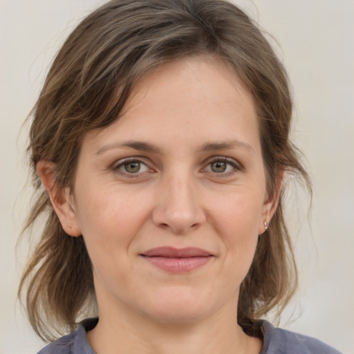 Joyful white adult female with medium  brown hair and grey eyes