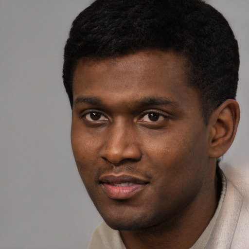 Joyful black young-adult male with short  black hair and brown eyes