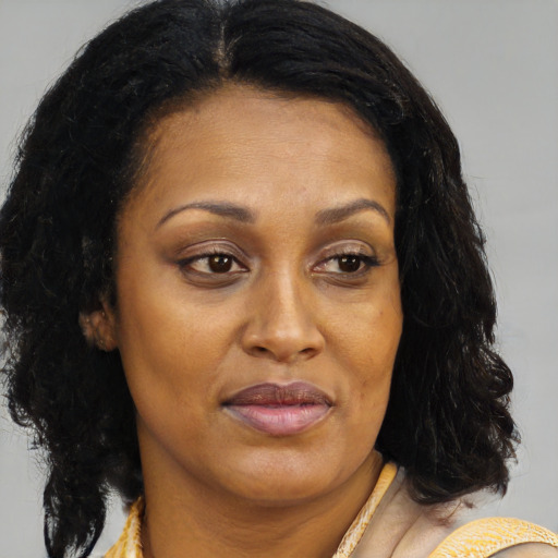Joyful black adult female with medium  brown hair and brown eyes