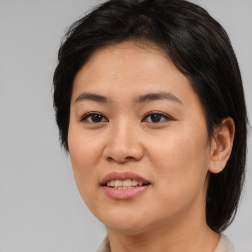 Joyful asian young-adult female with medium  black hair and brown eyes