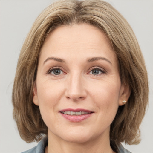 Joyful white adult female with medium  brown hair and grey eyes