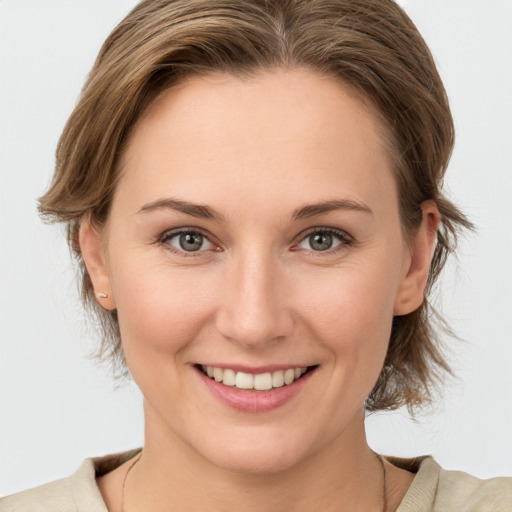 Joyful white young-adult female with medium  brown hair and grey eyes