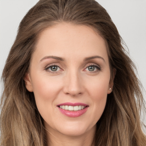 Joyful white young-adult female with long  brown hair and grey eyes