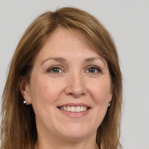 Joyful white adult female with long  brown hair and grey eyes