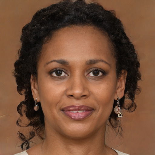 Joyful black adult female with medium  brown hair and brown eyes