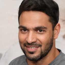 Joyful white adult male with short  black hair and brown eyes