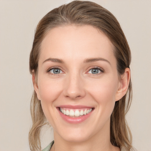 Joyful white young-adult female with long  brown hair and blue eyes