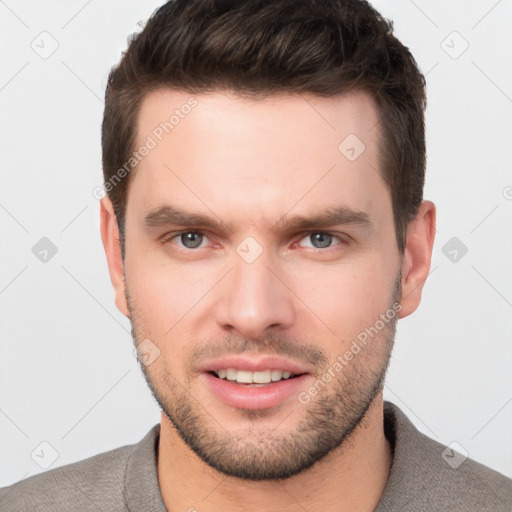 Joyful white young-adult male with short  brown hair and grey eyes