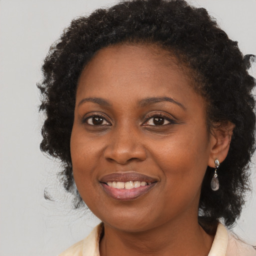 Joyful black young-adult female with long  brown hair and brown eyes