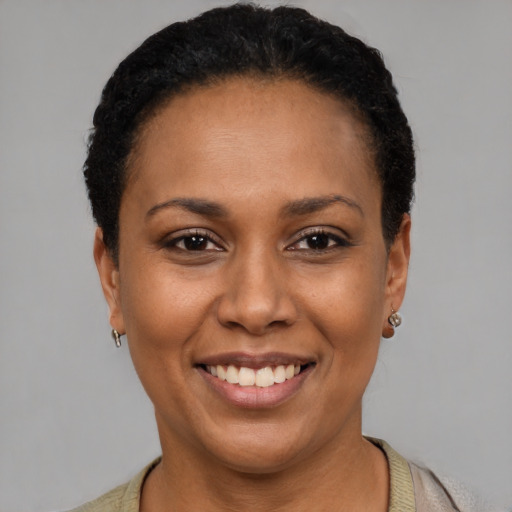 Joyful latino young-adult female with short  black hair and brown eyes