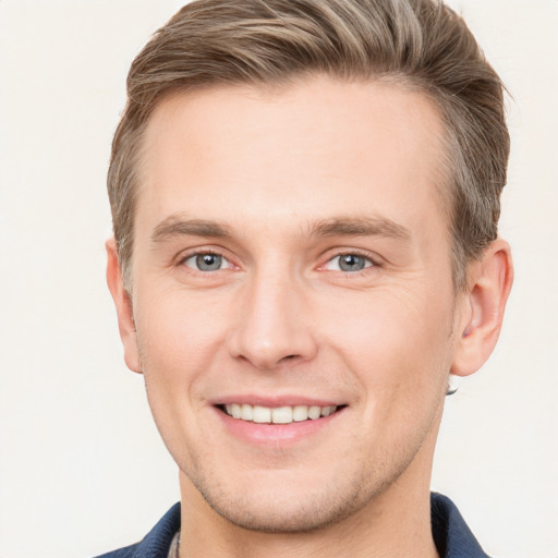 Joyful white young-adult male with short  brown hair and grey eyes