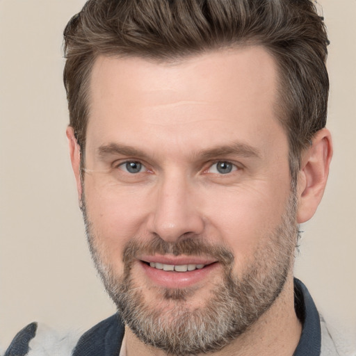 Joyful white adult male with short  brown hair and brown eyes