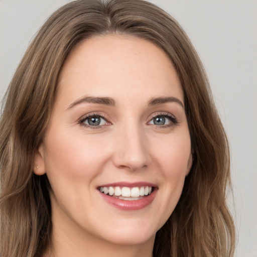 Joyful white young-adult female with long  brown hair and grey eyes