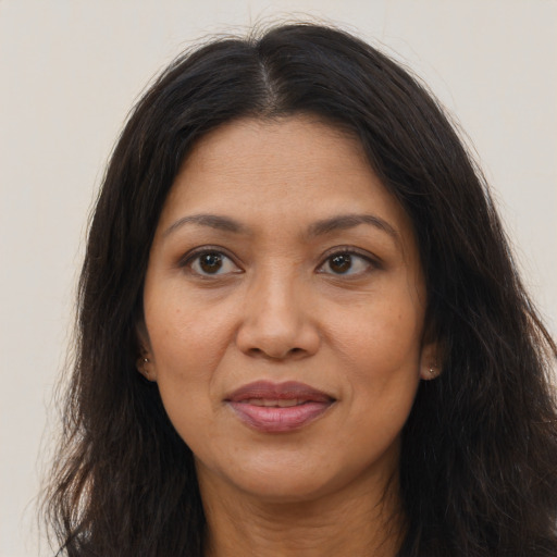 Joyful latino adult female with long  brown hair and brown eyes