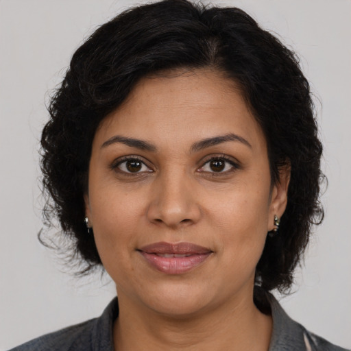 Joyful latino adult female with medium  brown hair and brown eyes
