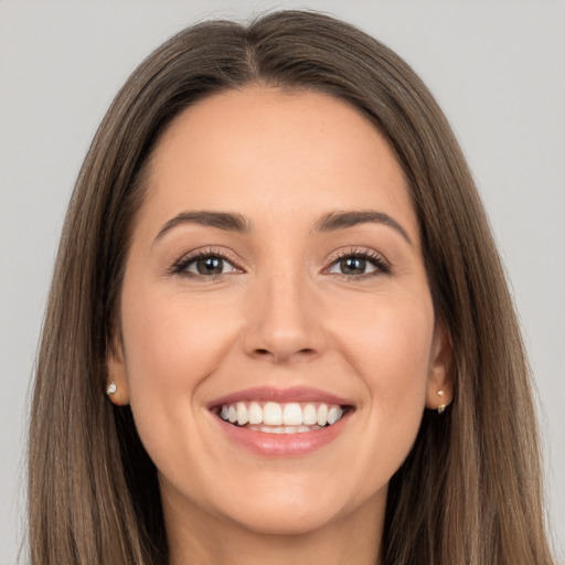 Joyful white young-adult female with long  brown hair and brown eyes