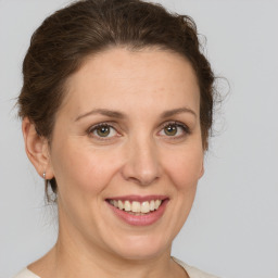 Joyful white adult female with medium  brown hair and grey eyes