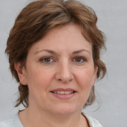 Joyful white adult female with medium  brown hair and blue eyes