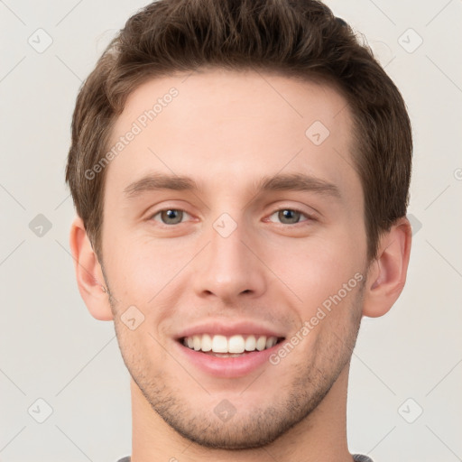 Joyful white young-adult male with short  brown hair and grey eyes