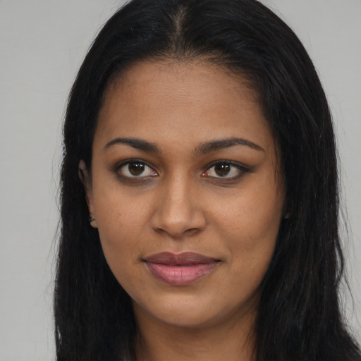 Joyful black young-adult female with long  brown hair and brown eyes