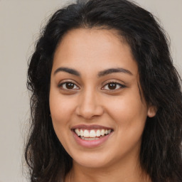 Joyful latino young-adult female with long  brown hair and brown eyes