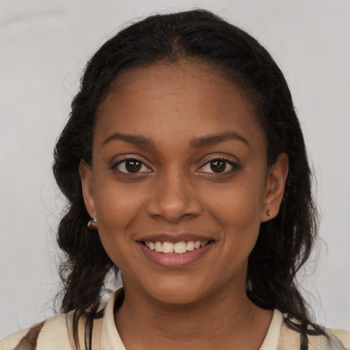 Joyful black young-adult female with medium  brown hair and brown eyes