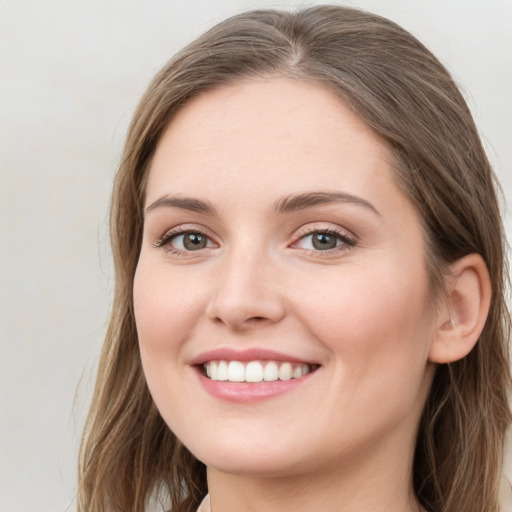 Joyful white young-adult female with long  brown hair and green eyes