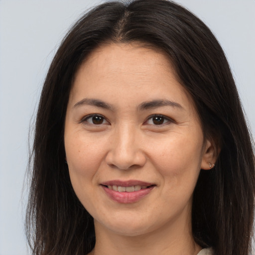 Joyful white adult female with long  brown hair and brown eyes