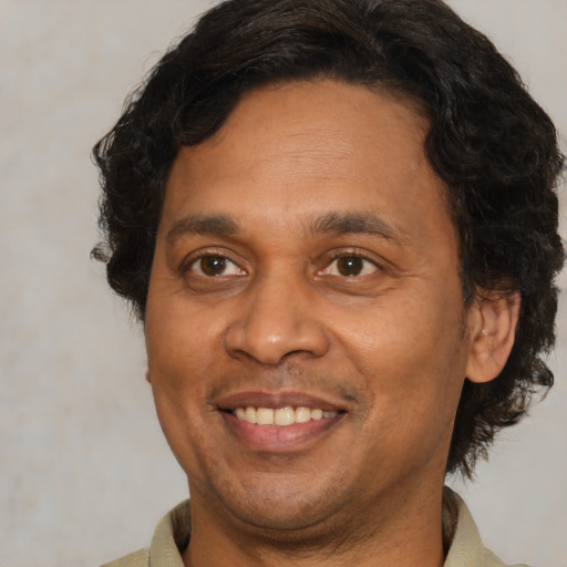 Joyful latino adult male with short  brown hair and brown eyes