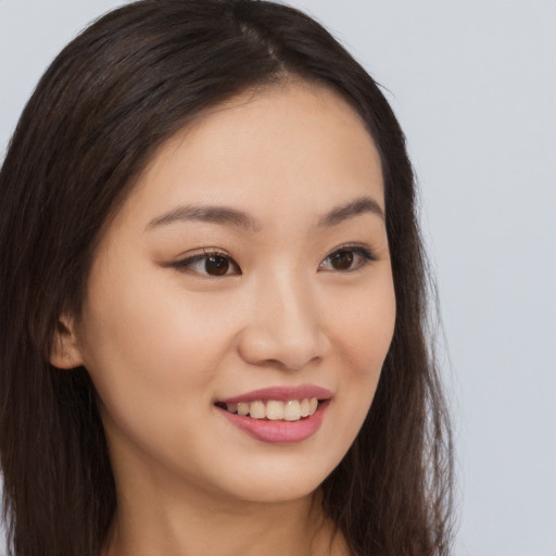 Joyful asian young-adult female with long  brown hair and brown eyes