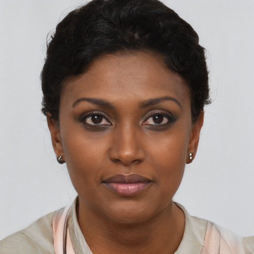Joyful black young-adult female with short  black hair and brown eyes