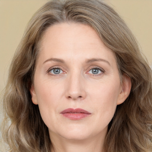 Joyful white adult female with long  brown hair and grey eyes