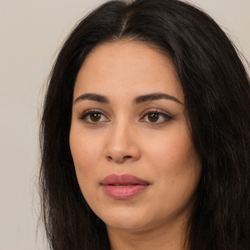 Joyful latino young-adult female with long  black hair and brown eyes