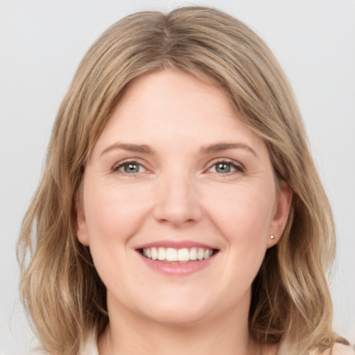 Joyful white young-adult female with medium  brown hair and blue eyes