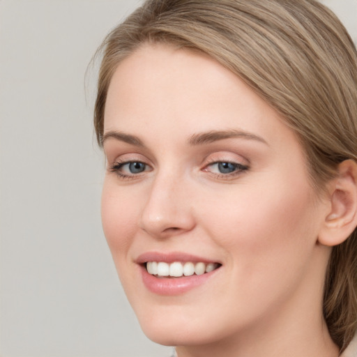 Joyful white young-adult female with long  brown hair and blue eyes