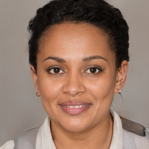 Joyful black young-adult female with short  brown hair and brown eyes