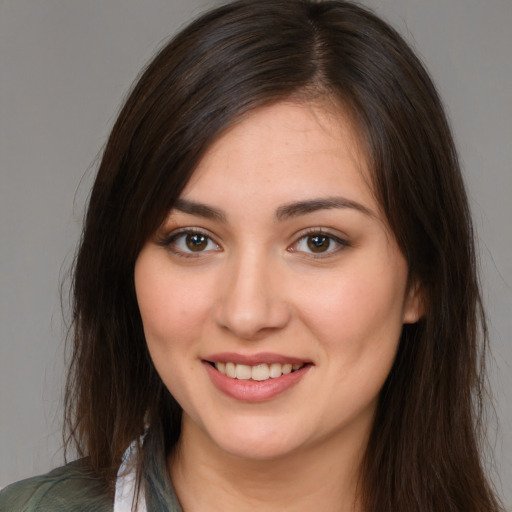 Joyful white young-adult female with long  brown hair and brown eyes