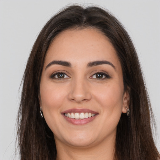 Joyful white young-adult female with long  brown hair and brown eyes