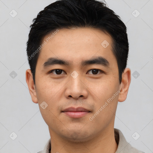 Joyful asian young-adult male with short  black hair and brown eyes