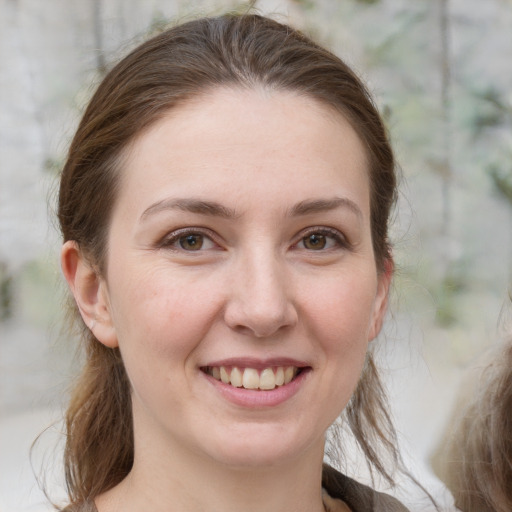 Joyful white young-adult female with medium  brown hair and grey eyes