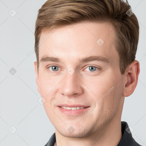 Joyful white young-adult male with short  brown hair and grey eyes